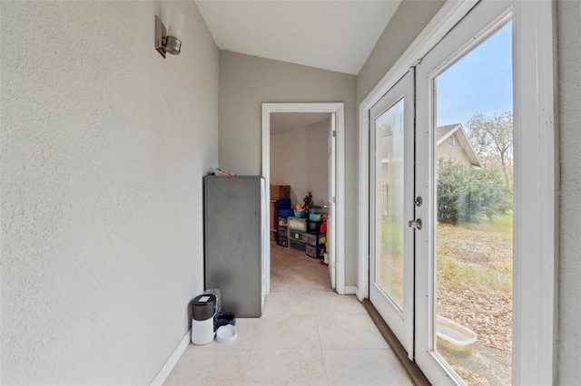 interior space featuring vaulted ceiling and light tile patterned flooring