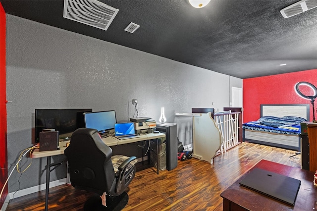 bedroom featuring a textured ceiling and dark wood-type flooring