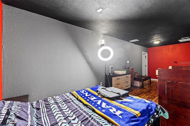 bedroom with dark wood-type flooring and a textured ceiling