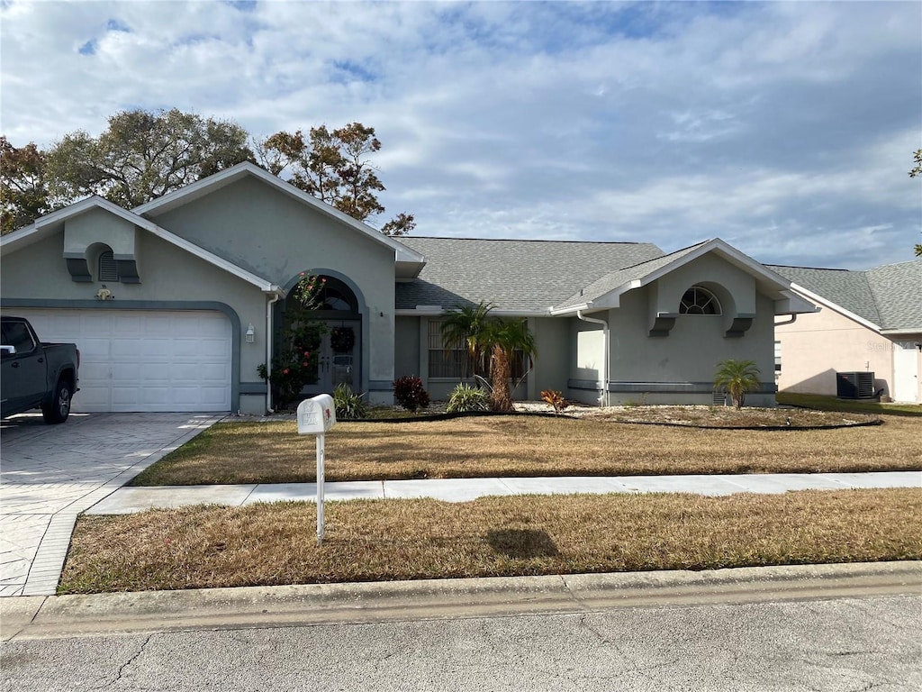 ranch-style home with central air condition unit and a garage