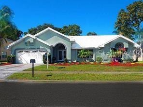 ranch-style home with an attached garage, driveway, and a front yard