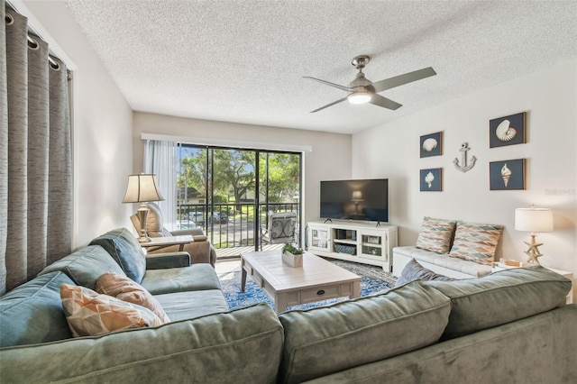 living room featuring ceiling fan and a textured ceiling