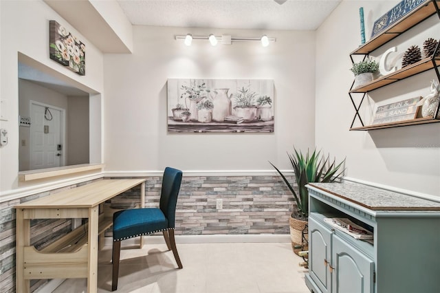 tiled office space featuring a textured ceiling