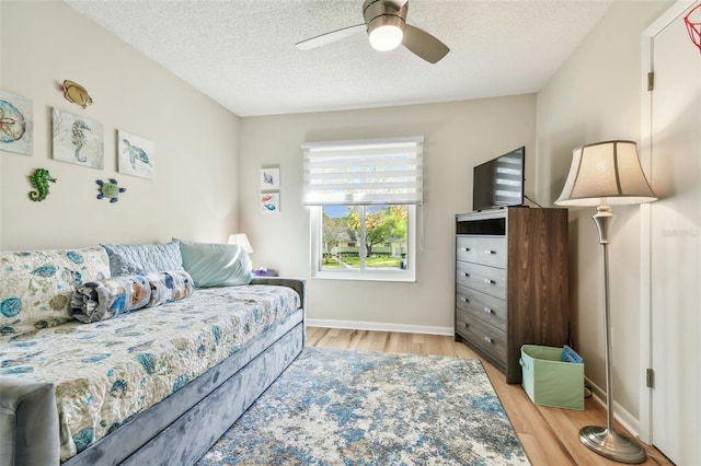 bedroom featuring a textured ceiling, light hardwood / wood-style flooring, and ceiling fan