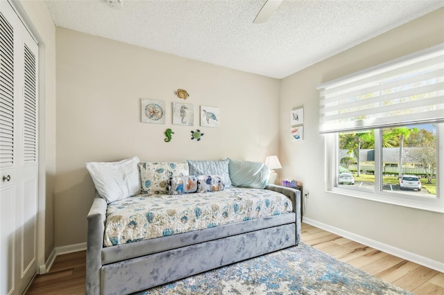 bedroom featuring hardwood / wood-style floors, ceiling fan, and a closet