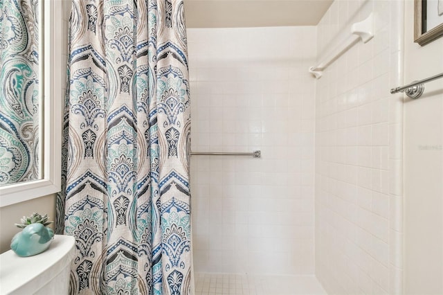 bathroom featuring a shower with shower curtain and toilet