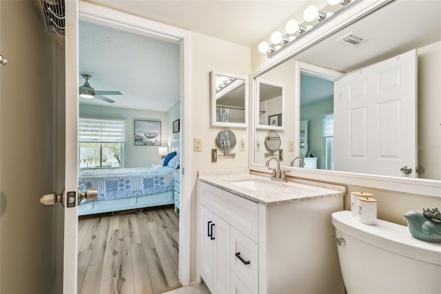 bathroom featuring hardwood / wood-style flooring, ceiling fan, toilet, and vanity