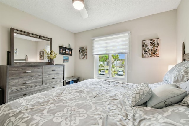 bedroom with ceiling fan and a textured ceiling