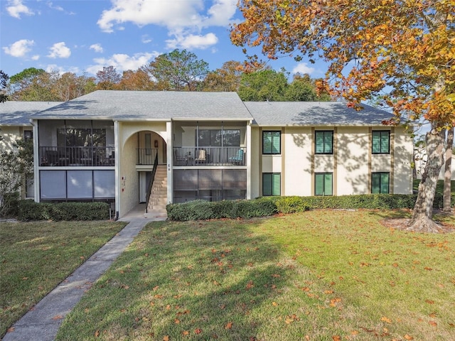 view of front of property featuring a sunroom and a front lawn