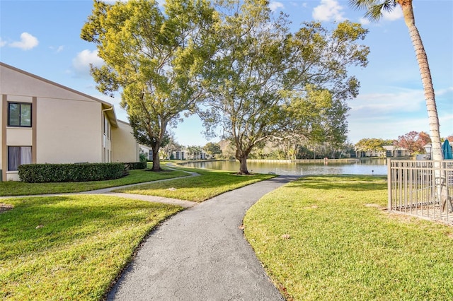 view of home's community featuring a lawn and a water view