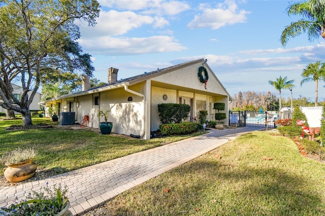 view of front of property with central AC unit and a front lawn