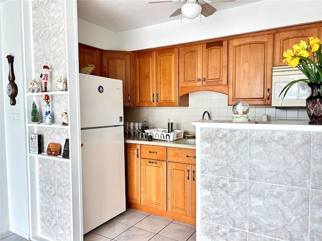 kitchen featuring ceiling fan, sink, tasteful backsplash, white appliances, and light tile patterned floors