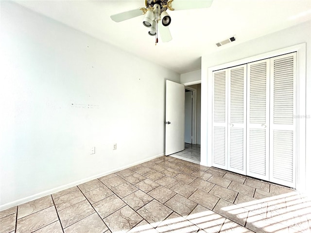 unfurnished bedroom with ceiling fan and a closet