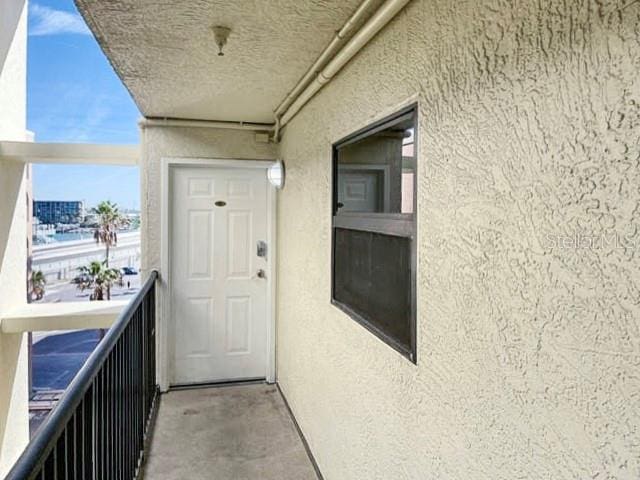 view of exterior entry with a balcony