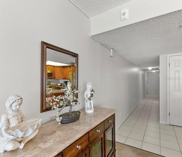 hallway featuring light tile patterned floors and a textured ceiling