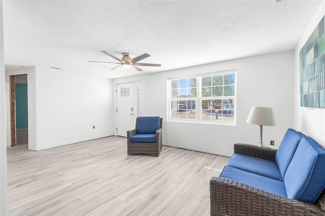 sitting room featuring ceiling fan, a textured ceiling, and light hardwood / wood-style flooring