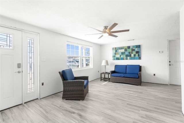 interior space featuring ceiling fan, a textured ceiling, and light hardwood / wood-style flooring