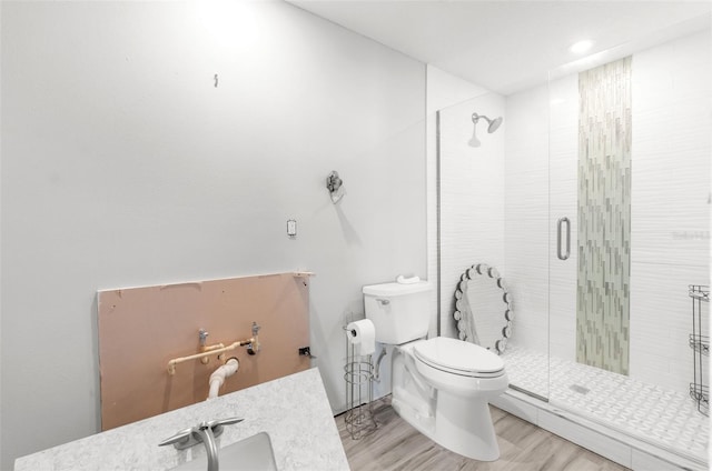 bathroom featuring hardwood / wood-style floors, toilet, and walk in shower