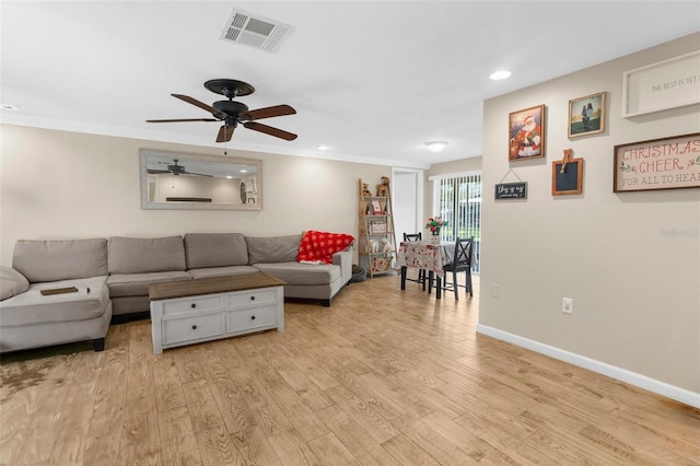 living room with crown molding, ceiling fan, and light hardwood / wood-style floors