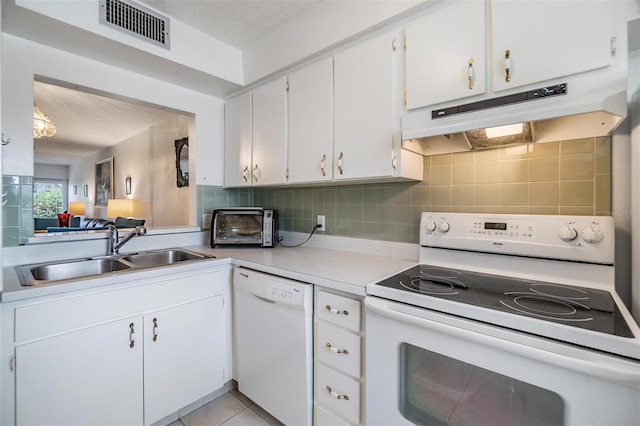 kitchen featuring decorative backsplash, white appliances, sink, white cabinetry, and light tile patterned flooring