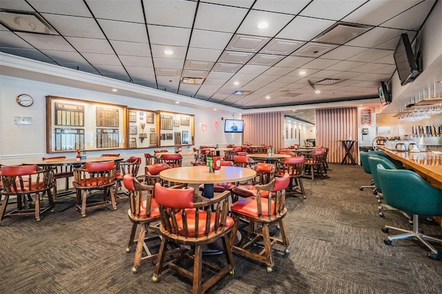 carpeted dining space featuring a paneled ceiling and crown molding