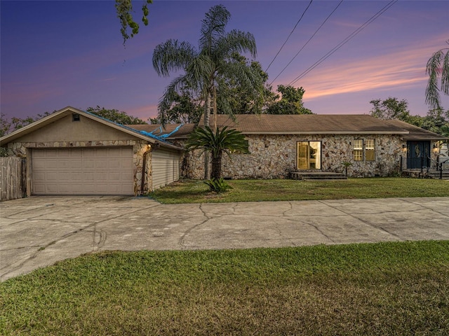 ranch-style home featuring a lawn and a garage