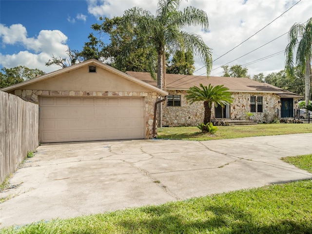 single story home featuring a front lawn and a garage