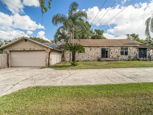 ranch-style house featuring a garage and a front lawn