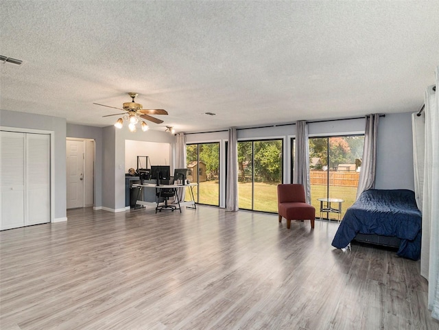 interior space with a textured ceiling, light hardwood / wood-style flooring, and ceiling fan