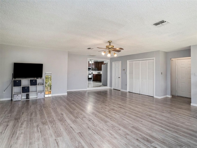 unfurnished living room with hardwood / wood-style floors, a textured ceiling, and ceiling fan