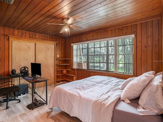 bedroom featuring ceiling fan and wooden walls