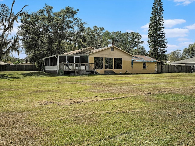 rear view of property featuring a yard and a deck