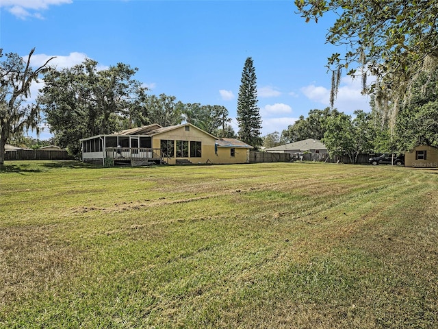 view of yard featuring a sunroom and a wooden deck