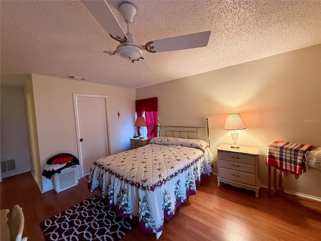 bedroom with ceiling fan, a textured ceiling, and light hardwood / wood-style flooring