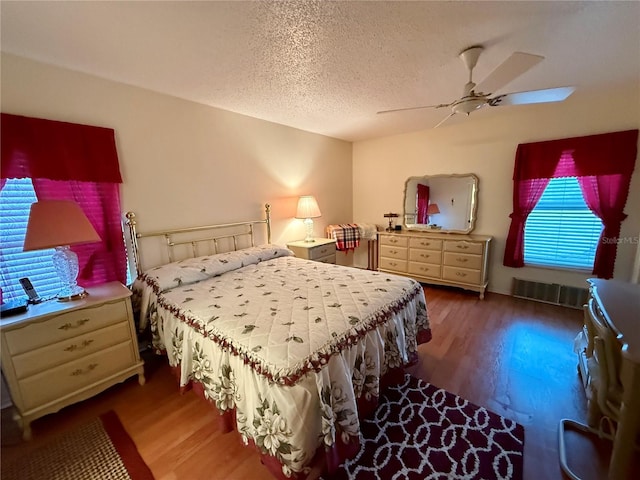 bedroom featuring a textured ceiling, hardwood / wood-style flooring, and ceiling fan