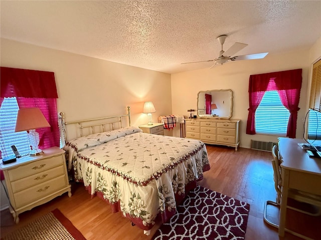 bedroom featuring a textured ceiling, dark hardwood / wood-style flooring, and ceiling fan