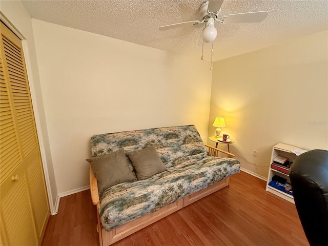 sitting room with hardwood / wood-style flooring, ceiling fan, and a textured ceiling