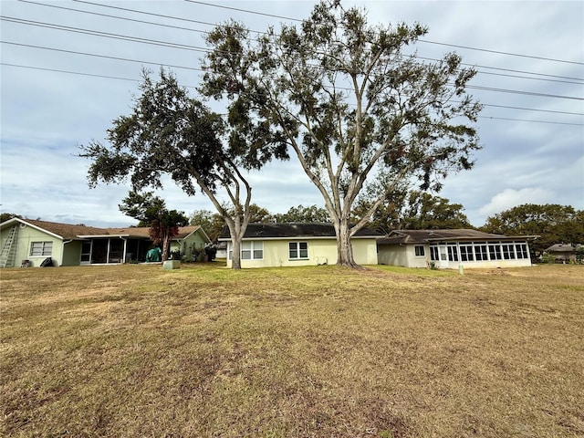 view of front facade with a sunroom and a front lawn