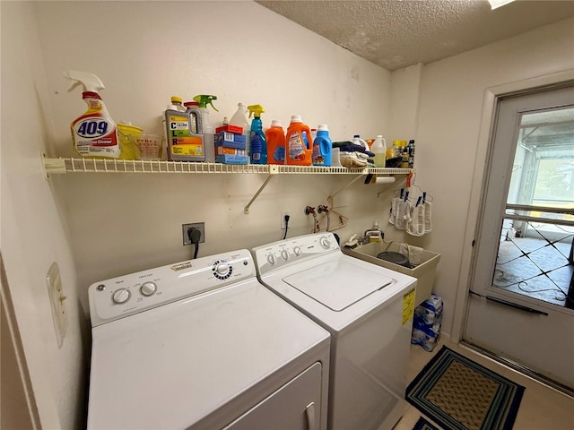 washroom with a textured ceiling, a sink, laundry area, and washer and dryer