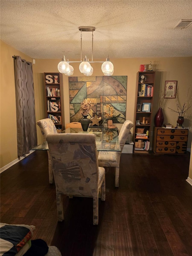 dining room featuring dark hardwood / wood-style flooring and a textured ceiling