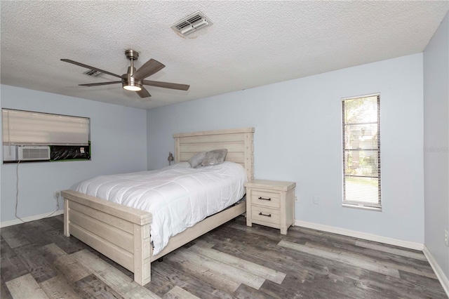 bedroom with ceiling fan, dark hardwood / wood-style flooring, cooling unit, and a textured ceiling