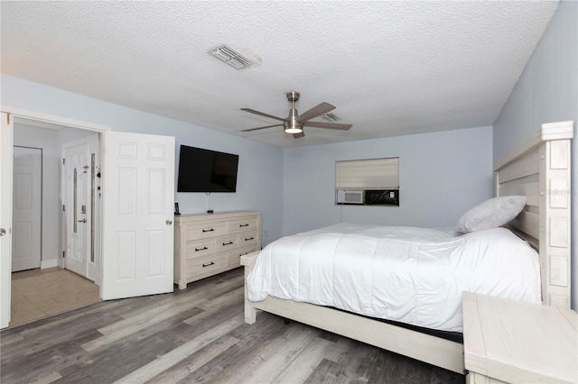 bedroom featuring hardwood / wood-style floors, a textured ceiling, and ceiling fan