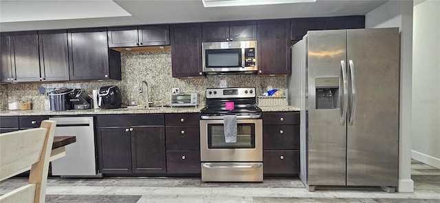 kitchen featuring dark brown cabinets, backsplash, and appliances with stainless steel finishes