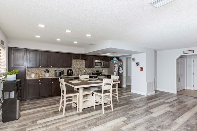 dining space with light hardwood / wood-style floors and a textured ceiling