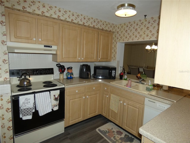 kitchen featuring sink, hanging light fixtures, dark wood-type flooring, an inviting chandelier, and white appliances