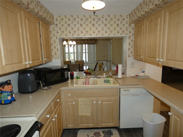 kitchen featuring dishwasher, sink, light brown cabinetry, a notable chandelier, and range