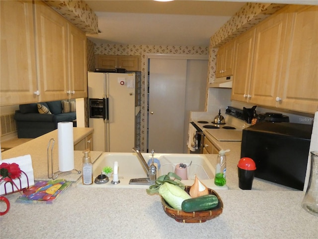 kitchen featuring light brown cabinets and white appliances