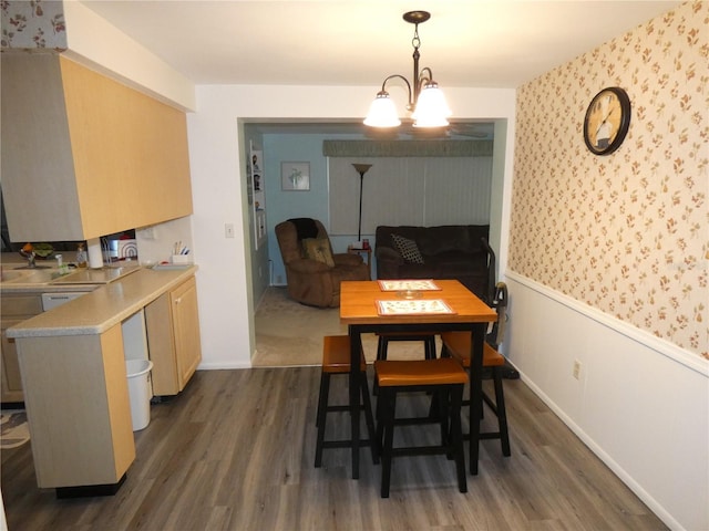 dining space with sink, a chandelier, and dark hardwood / wood-style floors