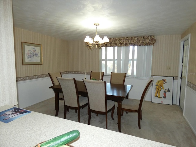 carpeted dining space with a chandelier