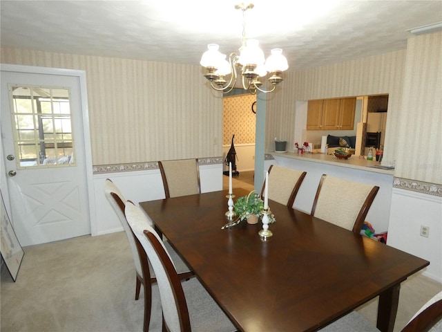 dining area featuring a notable chandelier and light carpet